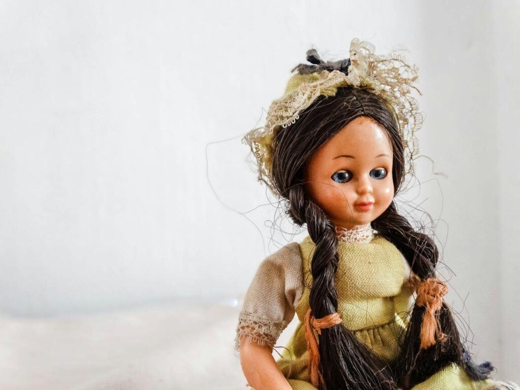 Close-up of a vintage doll wearing traditional attire, featuring intricate lace details.