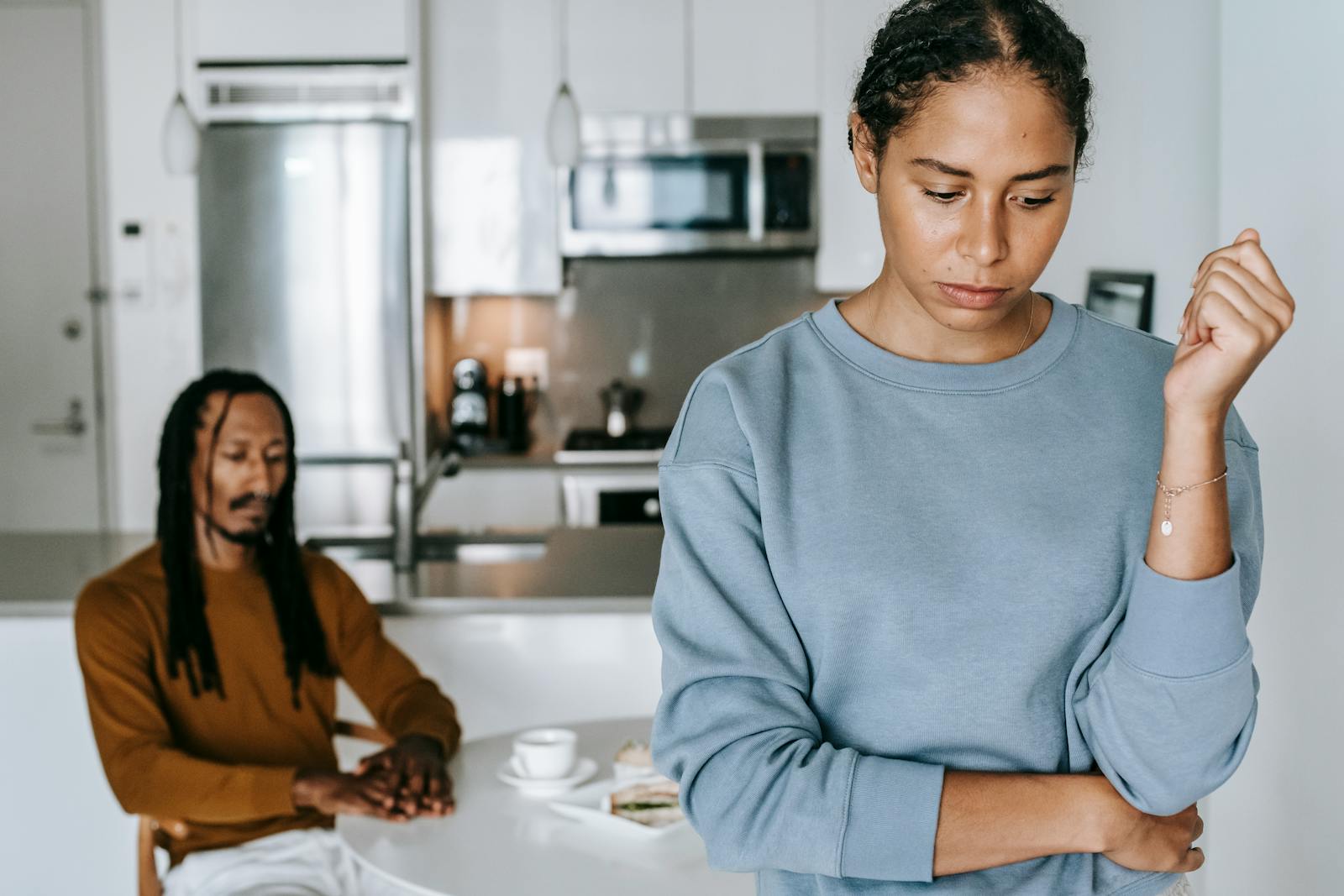 A couple in a kitchen experiencing a tense moment, reflecting on relationship issues.