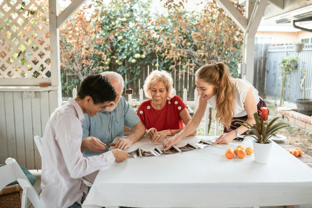 A happy family gathered around a table, sharing memories while looking at photos.