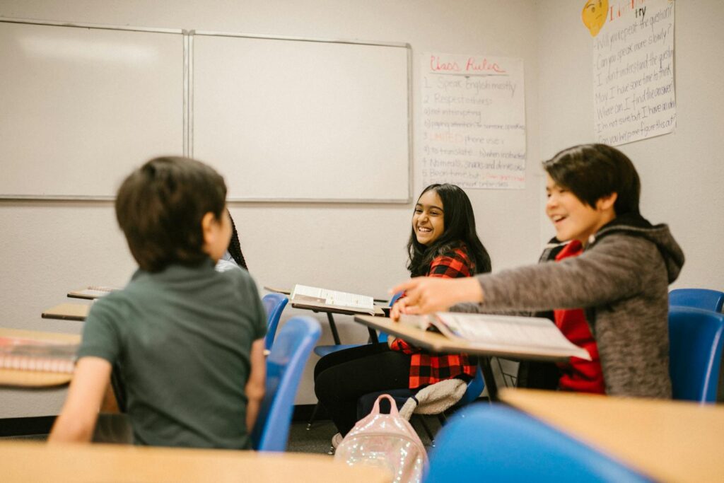 Happy students interacting and laughing together in a classroom environment.