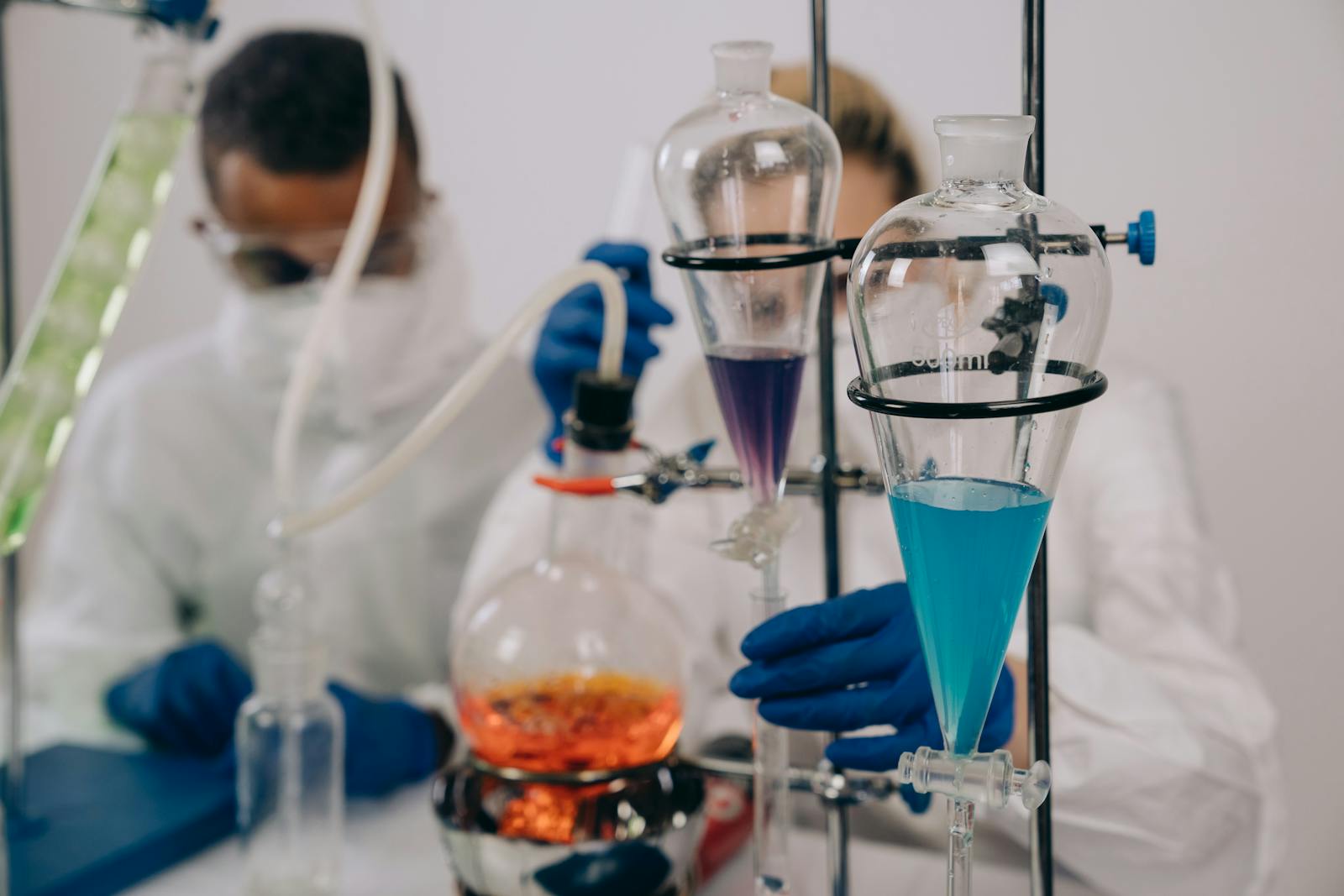 Scientists in protective gear conducting chemical experiments in a lab environment.
