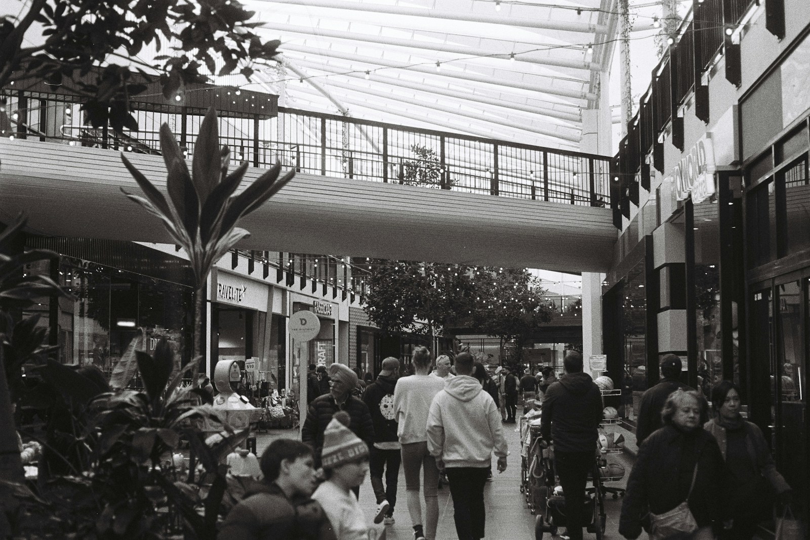 A black and white photo of people walking in a mall