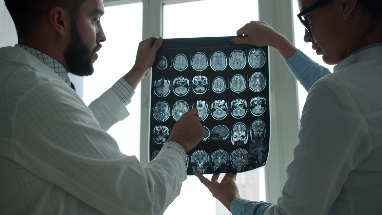Two doctors examining a brain mri scan together.