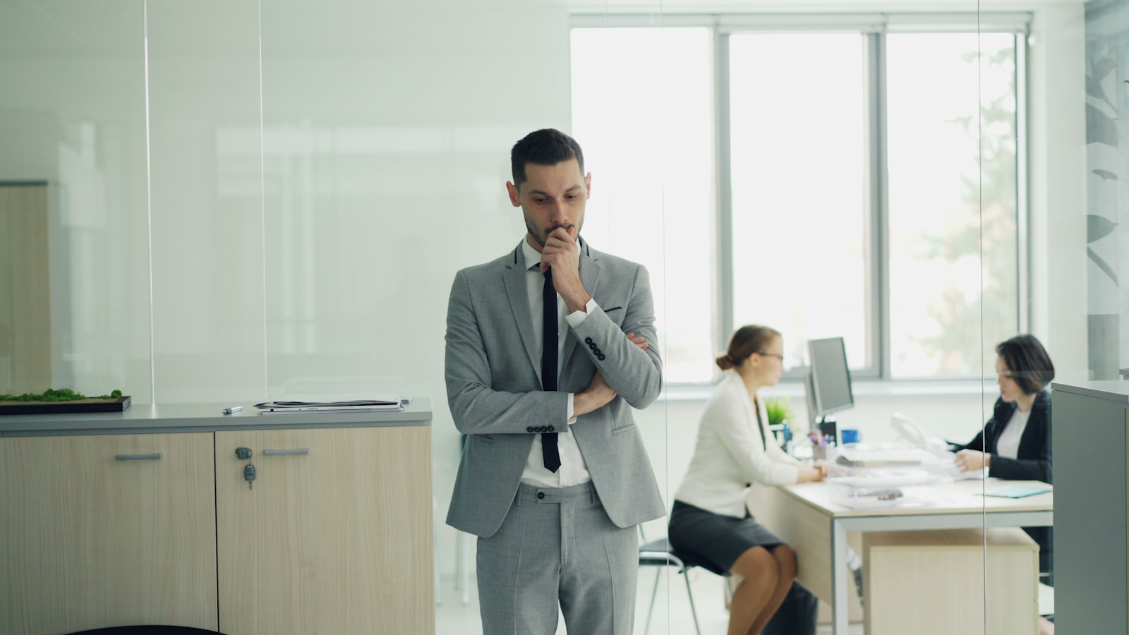 Man in suit thinking in modern office environment