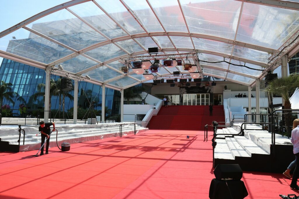 A man riding a skateboard down a red carpet covered walkway