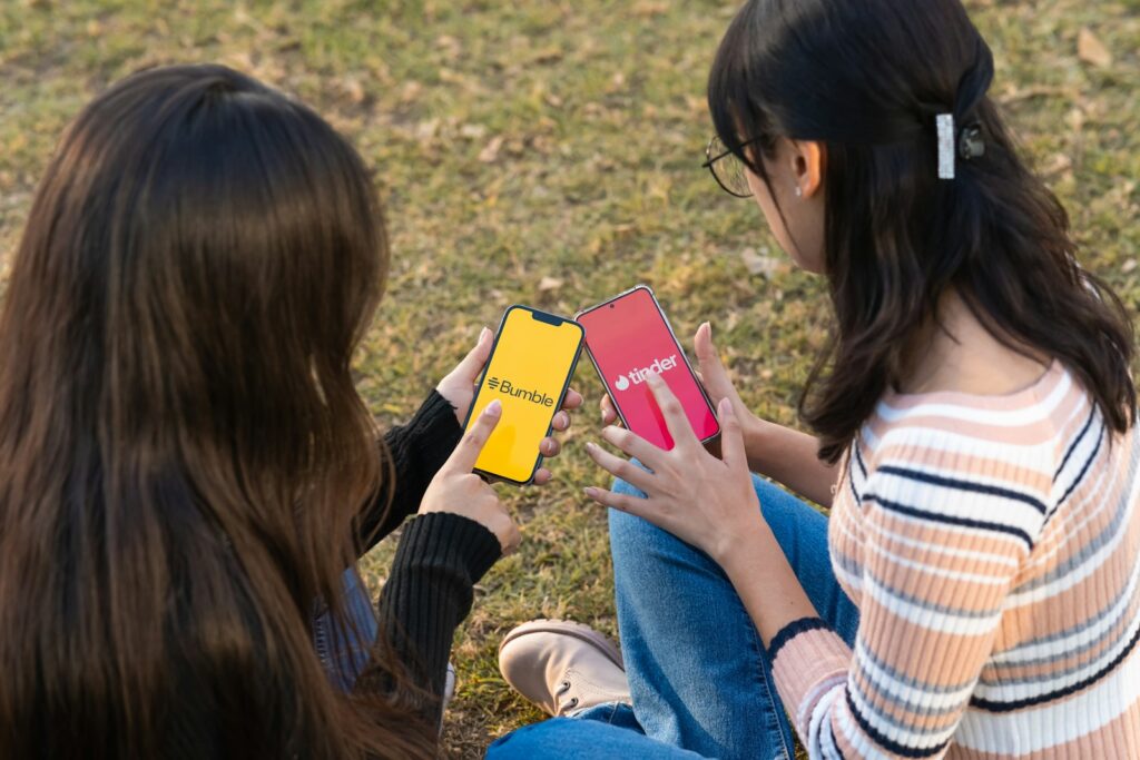 Two girls sitting on the ground looking at a book