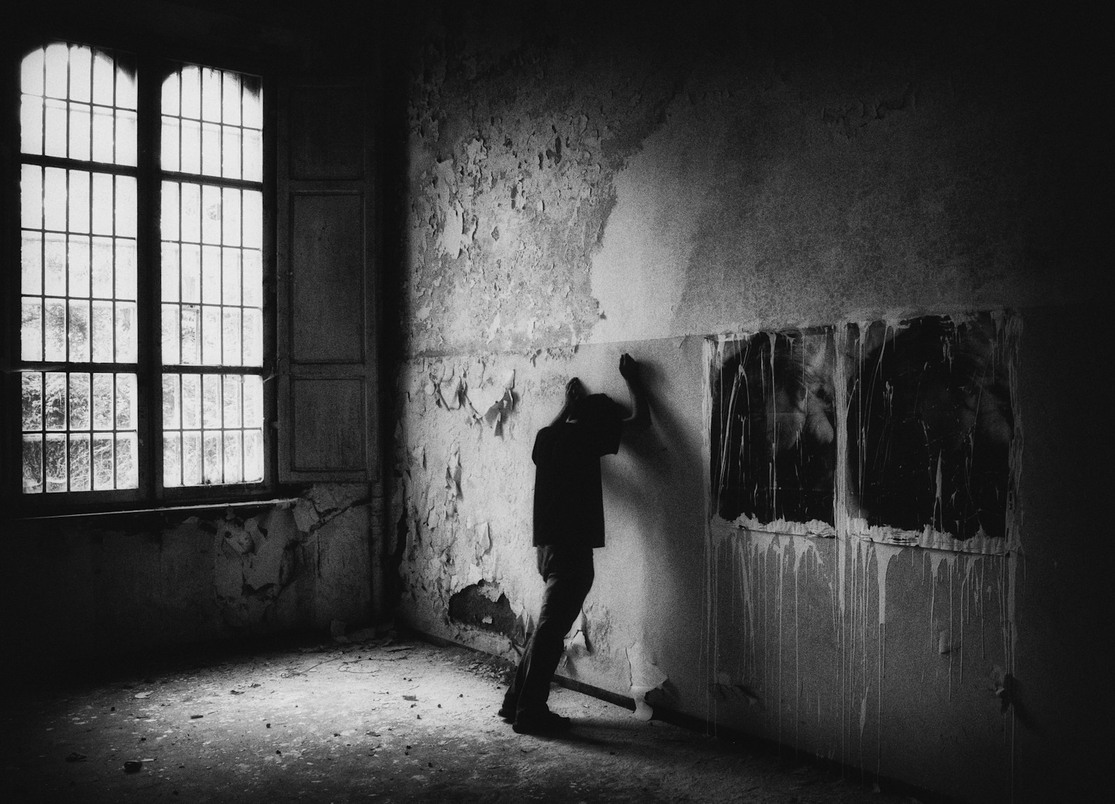 a man is painting a wall in a dark room
