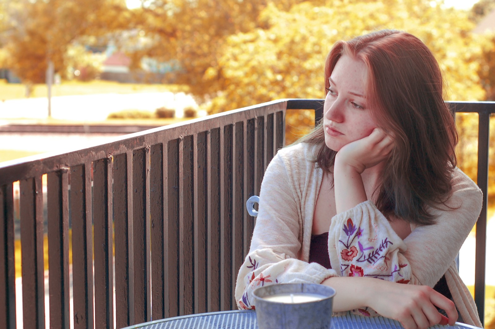 woman resting her face on her left hand while looking near railings