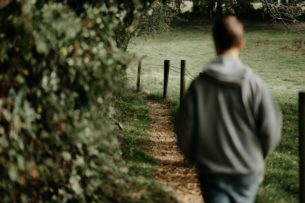 a man walking down a path in the woods