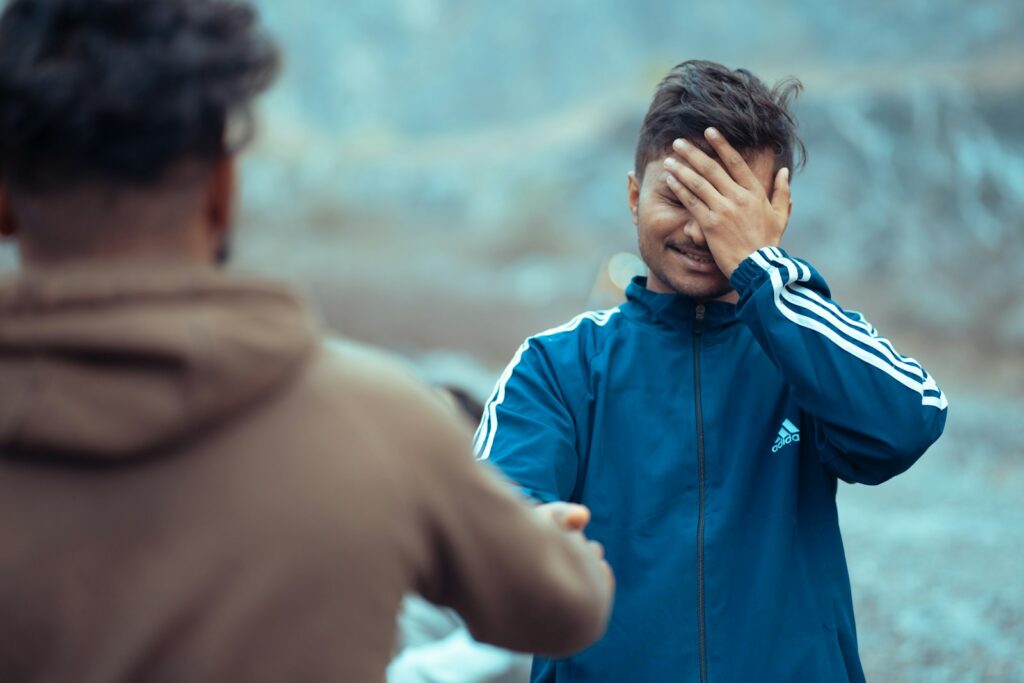 a man covering his face with his hands