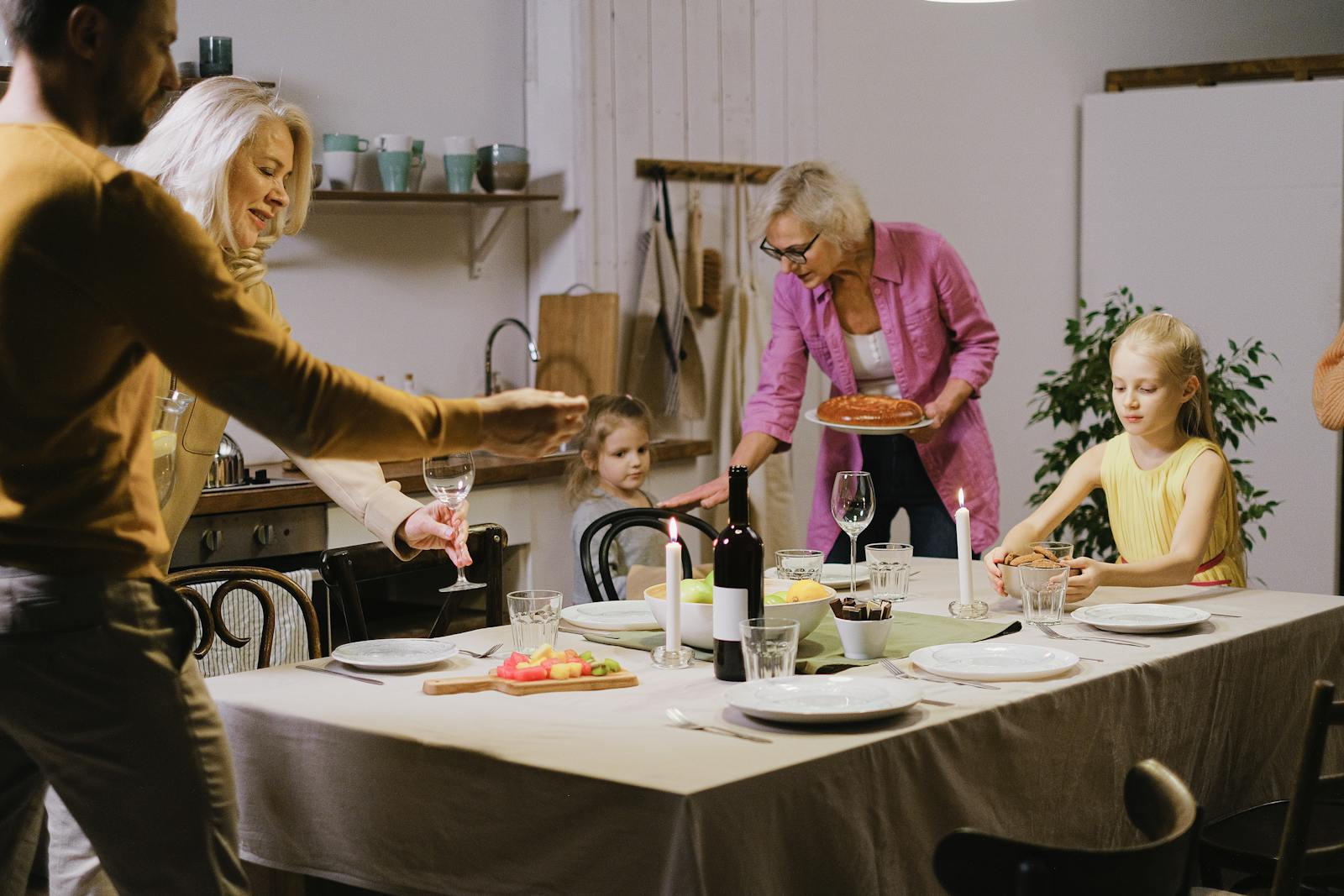 A warm family gathering indoors with multi-generational members enjoying dinner preparation.