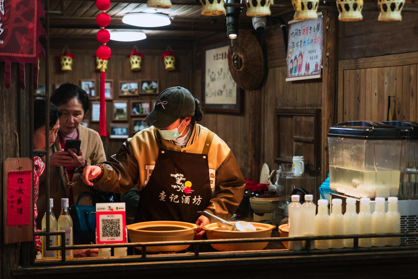 A traditional Chinese food stall indoors with staff preparing and serving drinks.