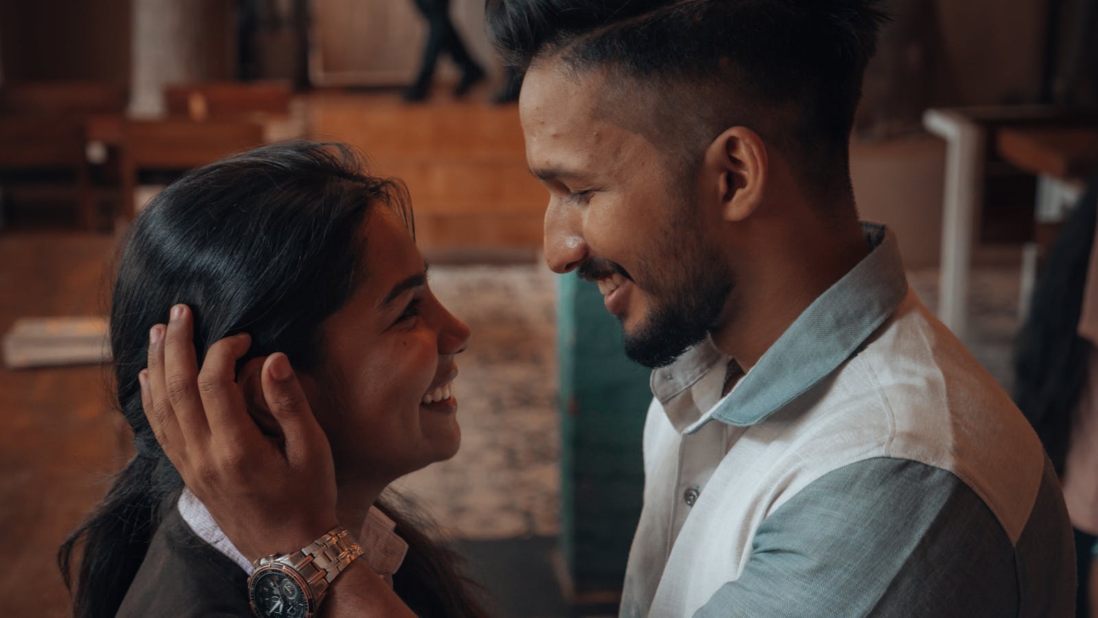 Charming photo of a couple sharing a tender moment in a cozy café atmosphere.