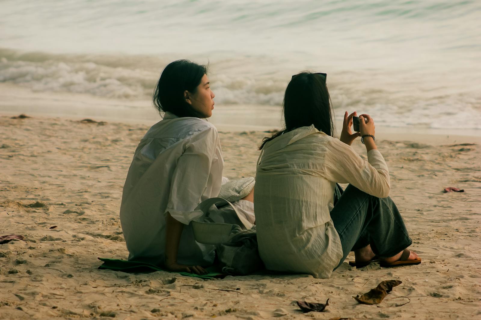 Two friends enjoying a peaceful moment on a sandy beach in Malay, Western Visayas, Philippines.