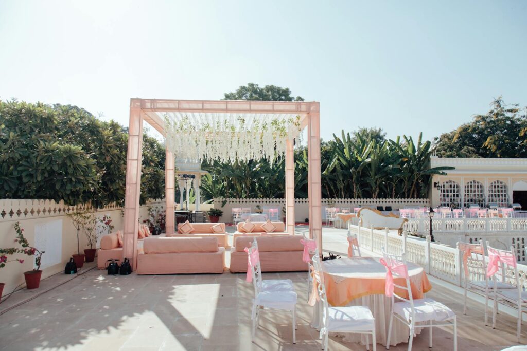 Beautiful outdoor wedding setup with pink decor and floral arrangements under clear skies.