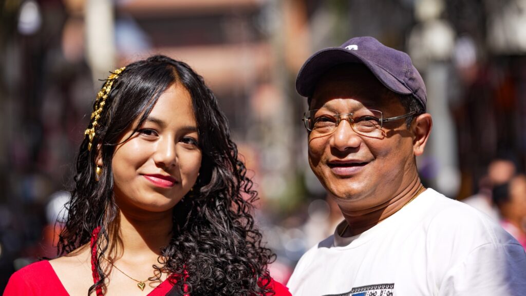 A young woman and an older man smiling.