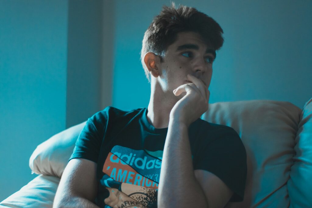 man wearing black shirt sitting on sofa