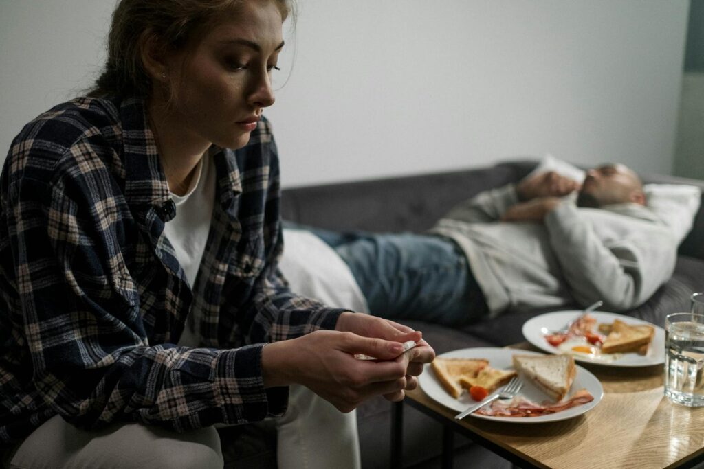 A couple in an intimate home setting reflecting on life's challenges, symbolized by untended breakfast.