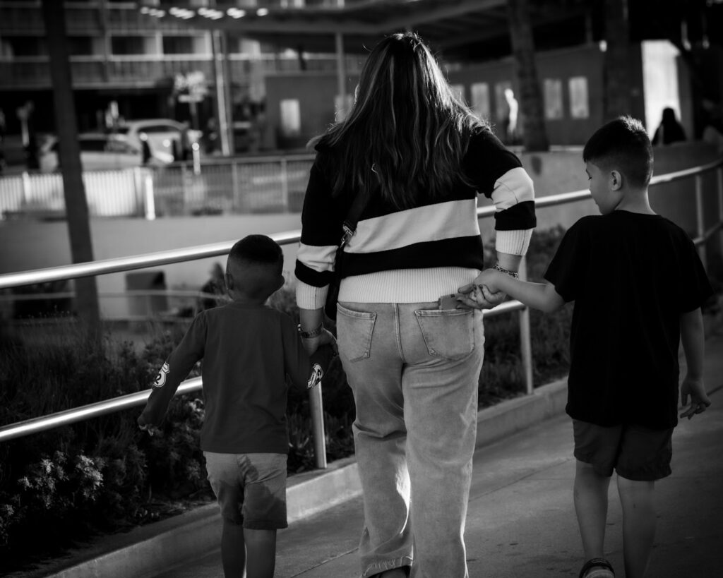 A mother and two children walk together.