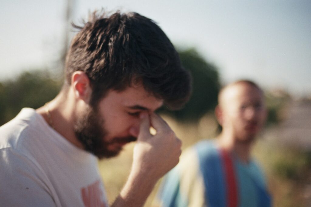 a man holding his hand to his face