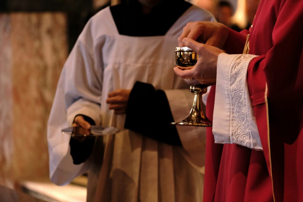 A priest is holding a chalice in a church