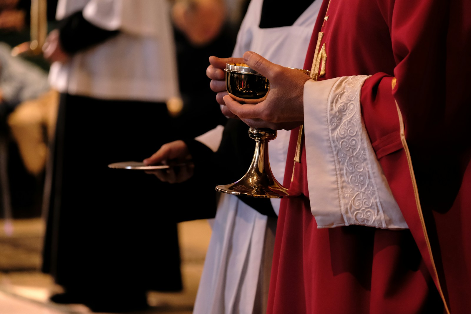 A priest is holding a chalice in a church