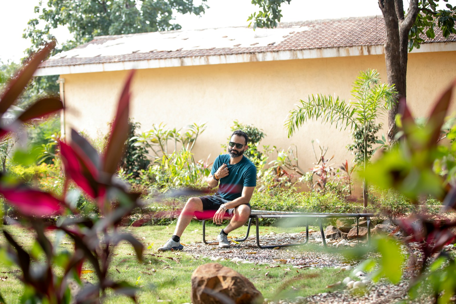 a man sitting on a bench in a garden