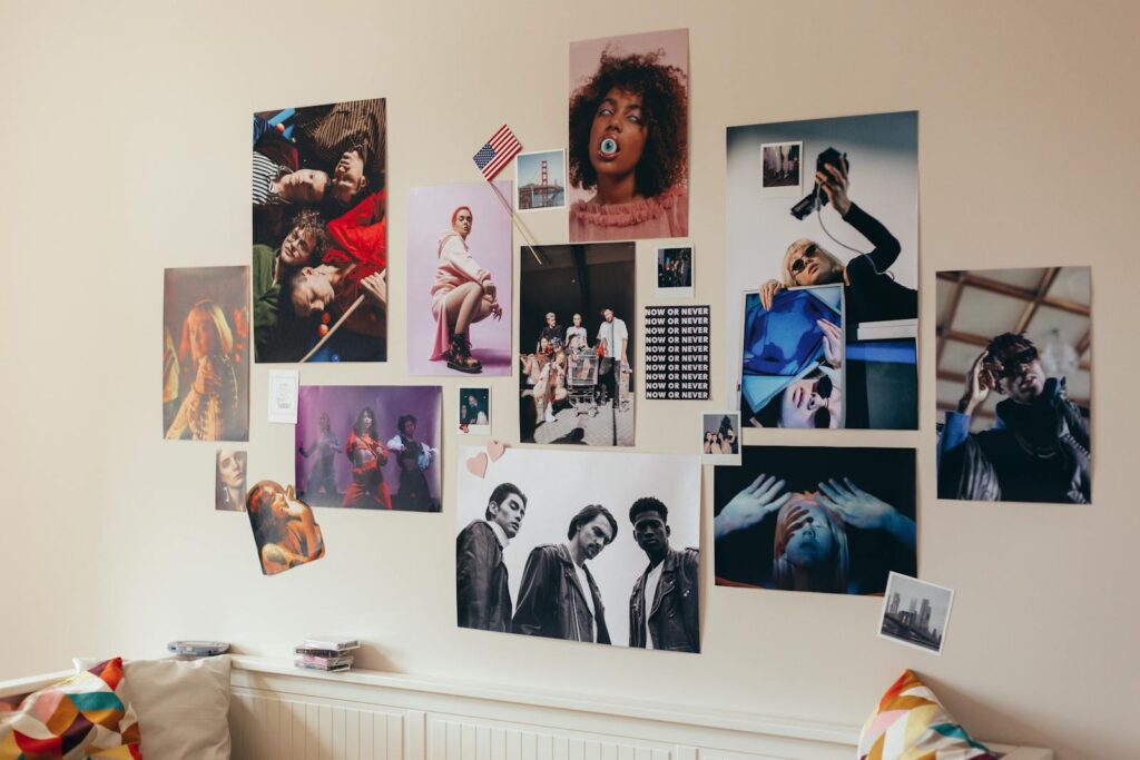 A creative photo collage decorates a room wall, featuring diverse and vibrant portraits.