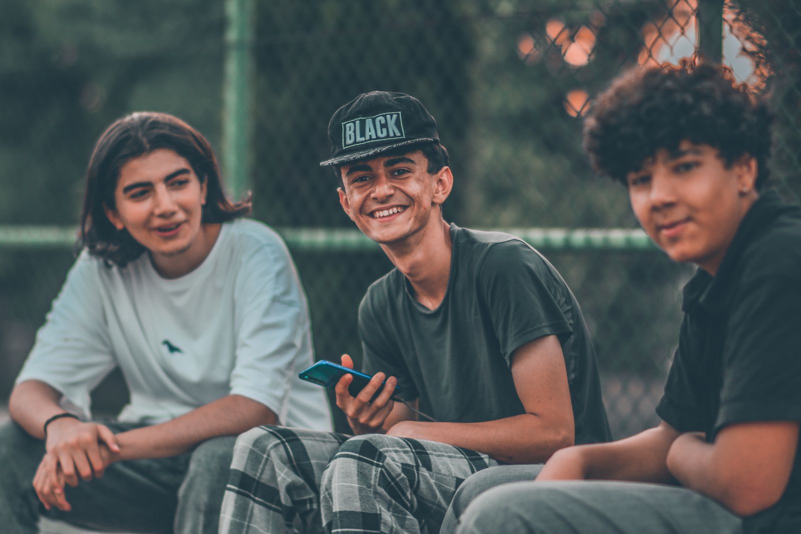 A group of smiling teenagers enjoying a casual outdoor hangout, capturing youthful energy and friendship.