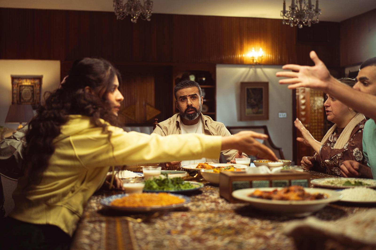 A lively family dinner with diverse group enjoying a meal and engaging in conversation.