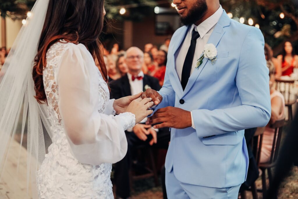 a bride and groom exchanging vows in front of an audience