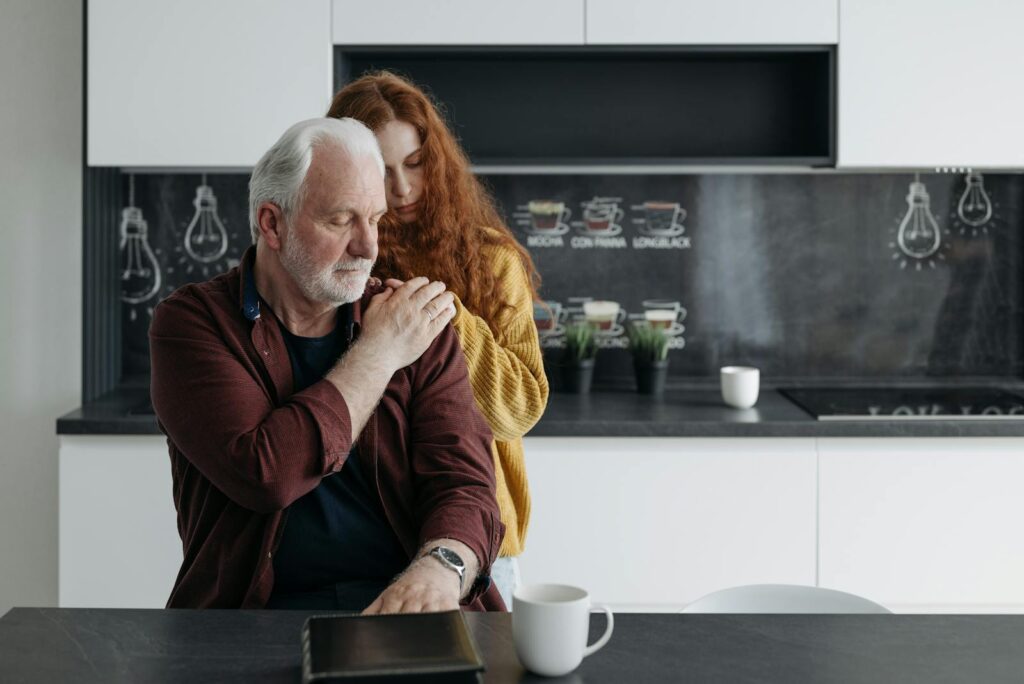 Emotional scene of a father and daughter sharing a tender, supportive moment in a modern kitchen.