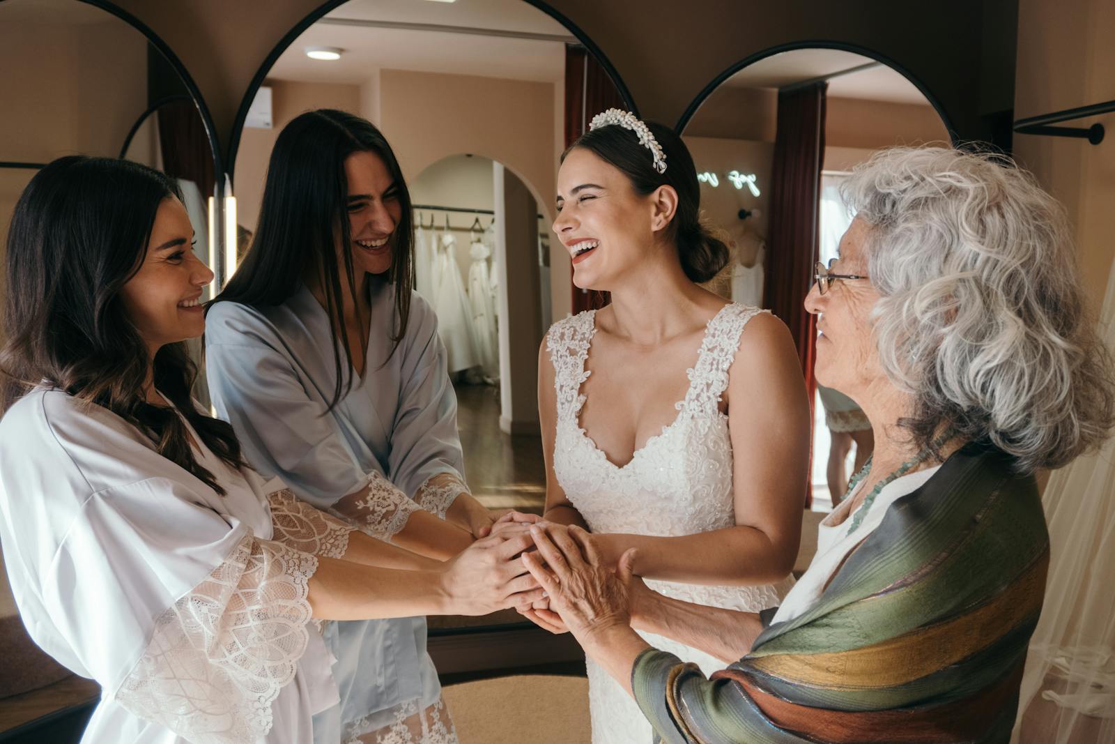 A bride shares a joyful moment with her loved ones before her wedding ceremony, captured indoors.