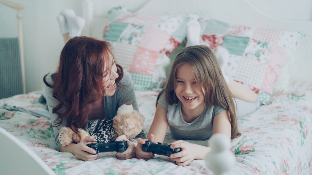 Mother and daughter are playing video games together.