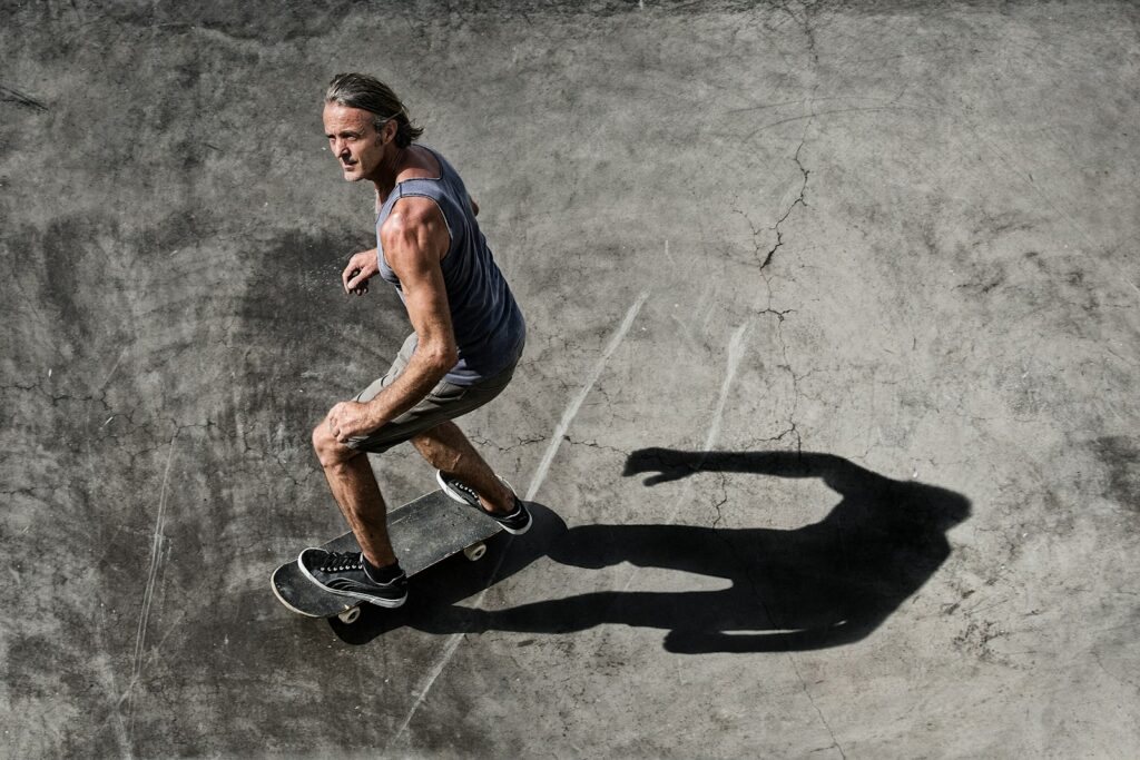 man in blue tank top and black shorts running on gray concrete floor