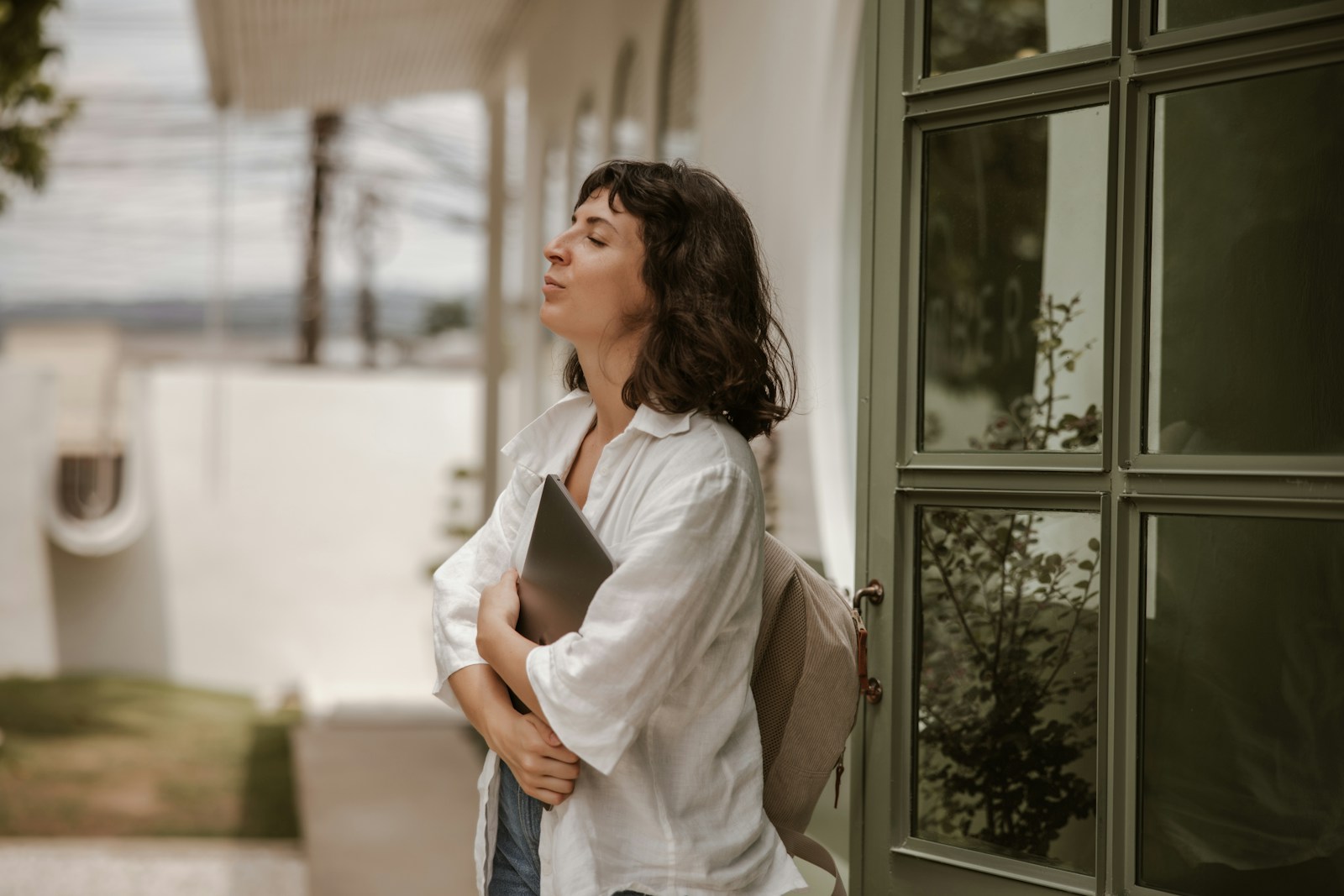 a woman standing outside of a building with a book in her hand