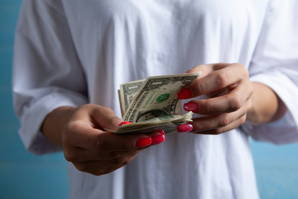 Hands holding a stack of dollar bills