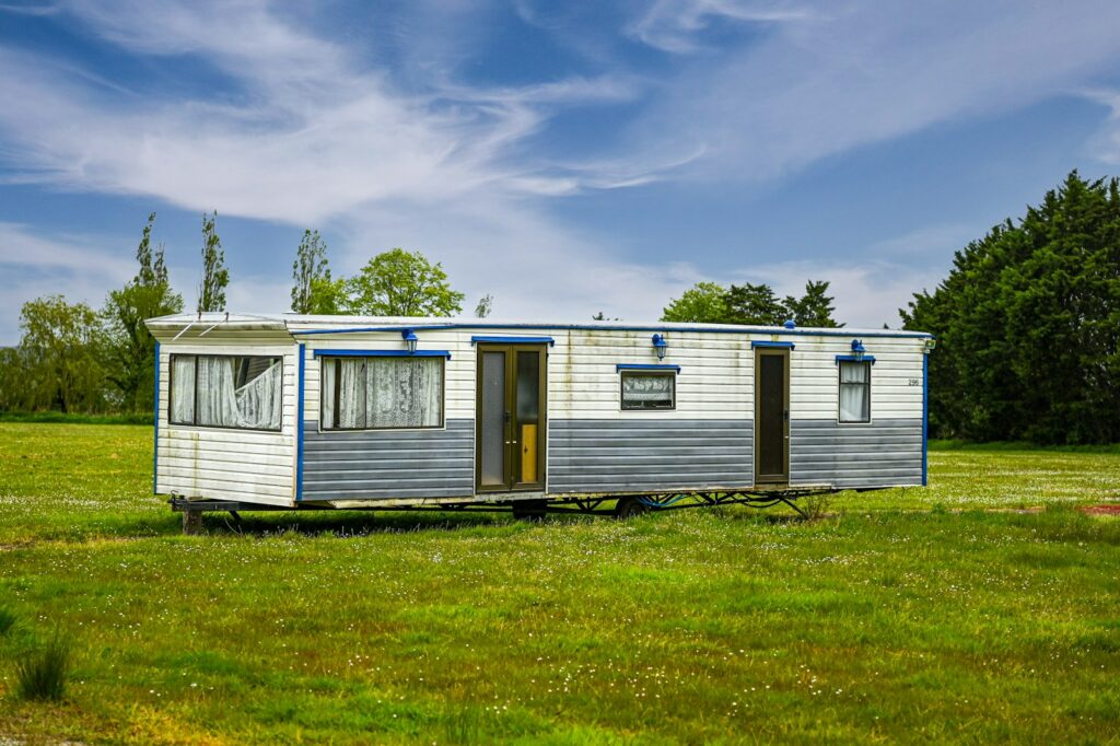 a mobile home sits in a grassy field