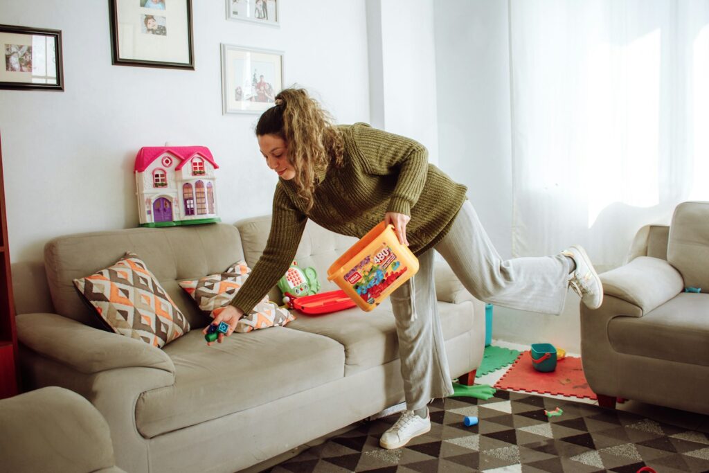 a person holding a box and a child on a couch