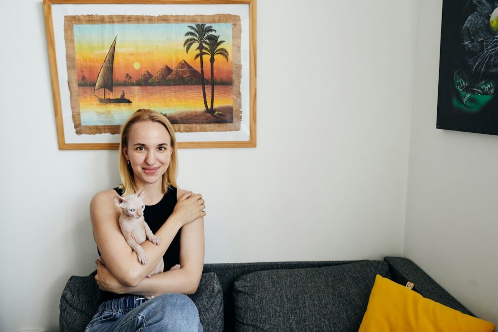 Woman holding a small cat on a couch