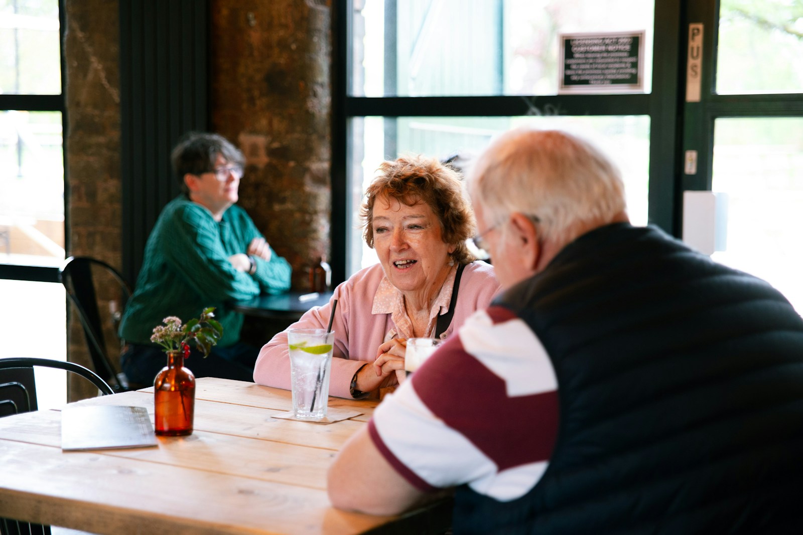 Two couples talking at a table in a cafe.