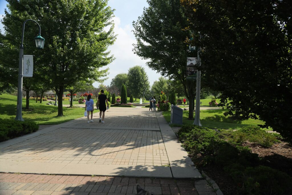 A group of people walking down a sidewalk