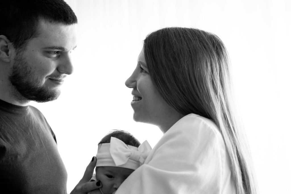 a man and woman holding a baby in their arms