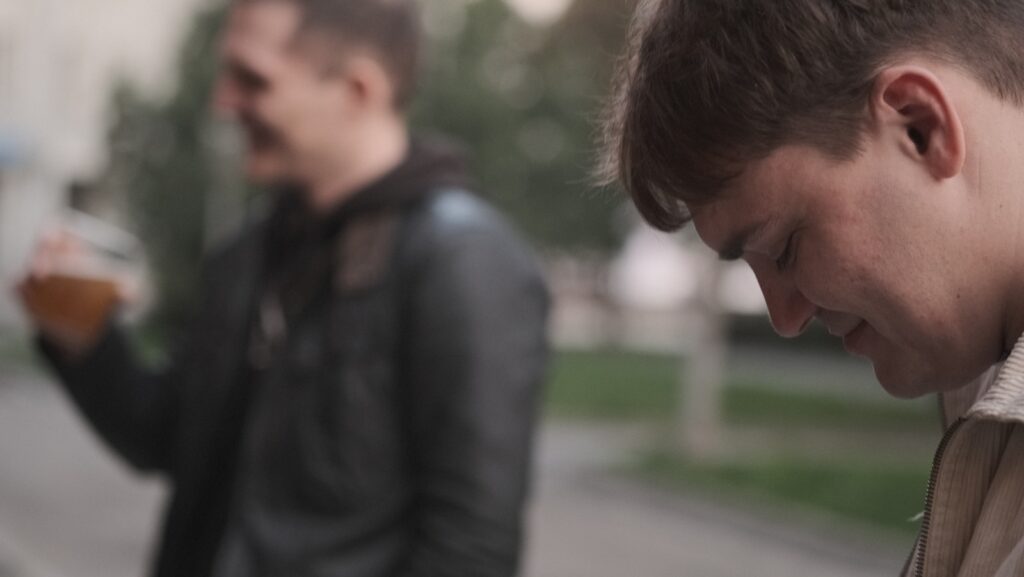 a man standing next to another man on a street