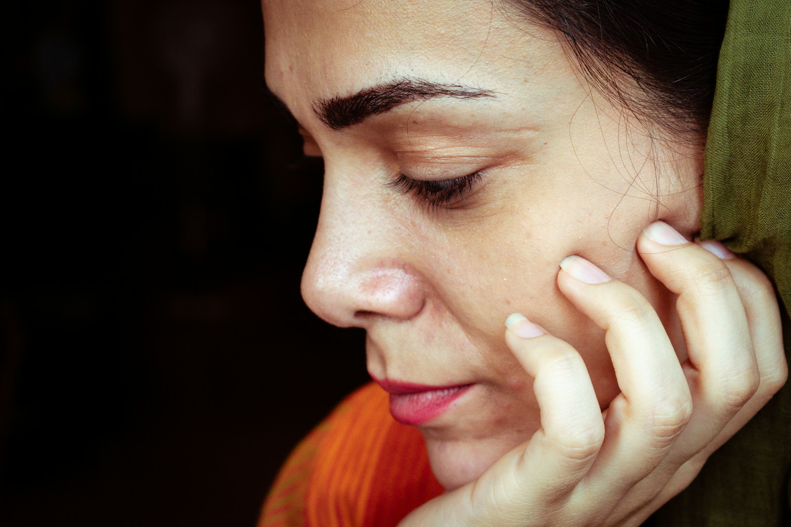 A woman's thoughtful profile in soft light