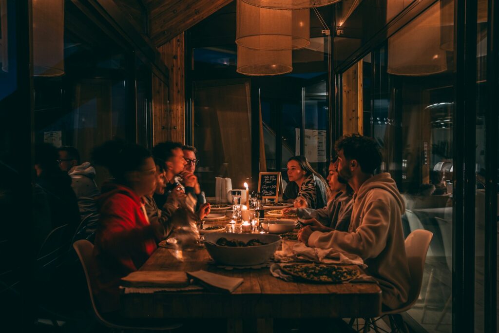 People enjoying a candlelit dinner at a dimly lit restaurant.