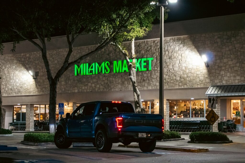 A truck parks outside milam's market at night.