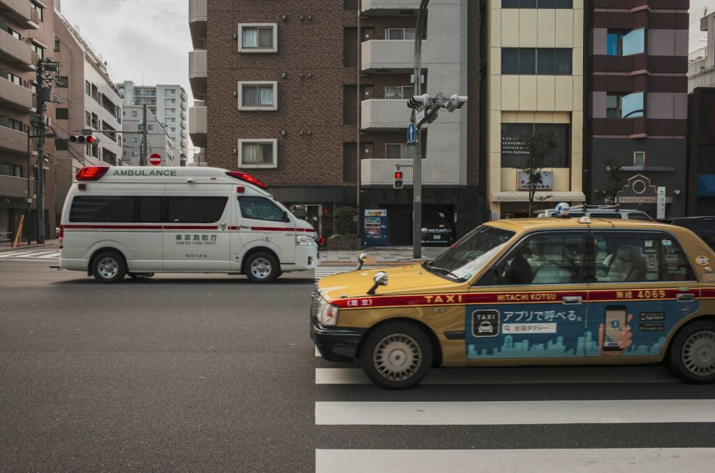 a taxi cab driving down a street next to tall buildings