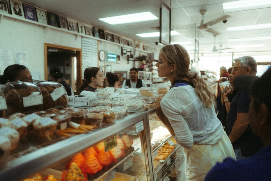 a group of people standing around a display of pastries