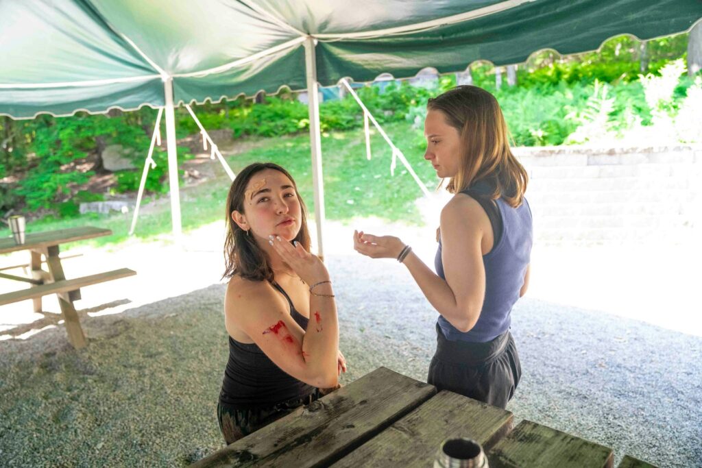 Two women talking under a tent.